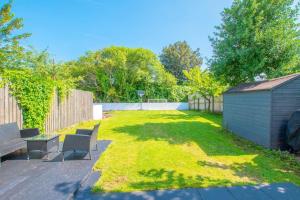 a yard with two chairs and a table and a fence at Sophisticated Home with Beautiful & Large Garden in Cardiff