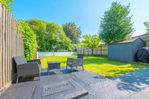 a patio with chairs and a table in a yard at Sophisticated Home with Beautiful & Large Garden in Cardiff +5 photos