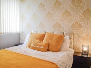a bed with orange pillows in a bedroom at 1 Ladyknowe - Uk39970 in Moffat