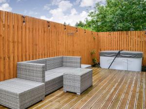 a patio with two wicker chairs and a fence at 1 Ladyknowe - Uk39970 in Moffat