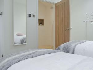 a bedroom with two beds and a mirror at The Milking Parlour in Keevil