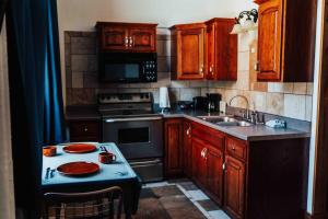 a kitchen with wooden cabinets and a stove top oven at Town Hall Inn in Lead