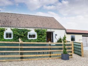 una casa con una valla de madera delante de ella en The Sheep Shed - Uk38437 en Kilham