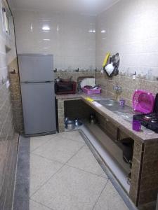 a kitchen with a refrigerator and a sink at لبلازا la plaza in Laayoune +8 photos