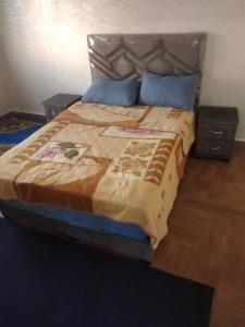 a bedroom with a large bed with two night stands at لبلازا la plaza in Laayoune