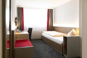 een slaapkamer met een bed, een bureau en een raam bij Hotel-Restaurant Bierhäusle in Freiburg im Breisgau