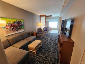a living room with a couch and a flat screen tv at Hyatt Place at The Hollywood Casino Pittsburgh South in Washington