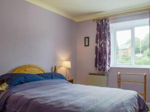 a bedroom with a bed and a window at Bear Cottage in Abbey Dore