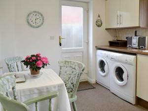 a kitchen with a table and a washing machine at The Annexe in Knaresborough
