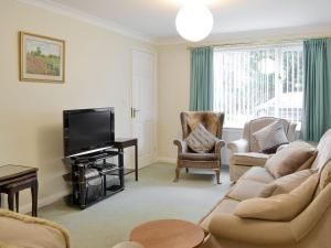a living room with a couch and a flat screen tv at The Annexe in Knaresborough
