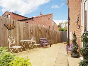 a patio with chairs and a table and a fence at The Annexe in Knaresborough