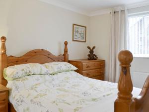 a bedroom with a bed and a dresser and a window at The Annexe in Knaresborough