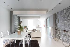 une salle à manger blanche avec une table blanche et un vélo sur le mur dans l'établissement LOFT EXCLUSIVO EN EL CENTRO, à Saragosse