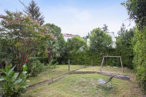 un parque infantil con columpio en un jardín en Beautiful house with a large yard at the heart of Hendaye - Welkeys, en Hendaya