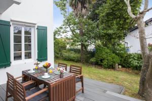 drewniany stół i krzesła na patio w obiekcie Maison de Belcenia - Hendaye - Welkeys w mieście Hendaye