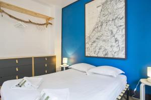 a bedroom with a large white bed with a blue wall at Beautiful house with a large yard at the heart of Hendaye - Welkeys in Hendaye