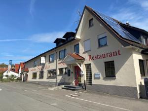 un bâtiment avec un restaurant sur le côté d'une rue dans l'établissement Landgasthaus Zollerstuben, à Bermatingen