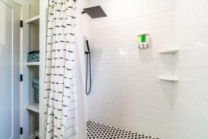 a bathroom with a shower with a black and white tile floor at Stylish 2-Bedroom walking distance to Downtown in Reno