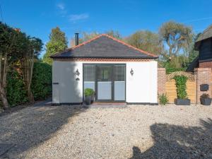 a white garage with a door in a driveway at The Old Meeting Hall in Kings Somborne