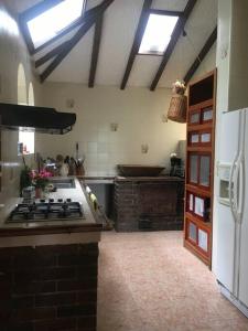a kitchen with a stove and a white refrigerator at Hermosa casona sobre la represa la Esmeralda in Somondoco