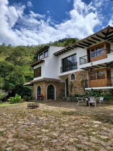 a large house with a yard in front of it at Hermosa casona sobre la represa la Esmeralda in Somondoco