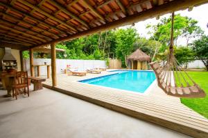 un patio con una hamaca y una piscina en Casa João Viera Trancoso, en Trancoso