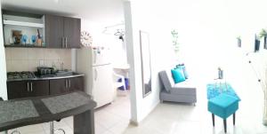 a kitchen and a living room with a couch and a table at Vacaciona a 3 minutos del Parque del Cafe in Armenia +7 photos