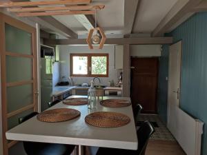una cocina con una mesa con cuatro platos. en L'Absolu en Orvault