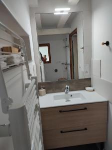 uma casa de banho com um lavatório e um espelho em L'Absolu em Orvault