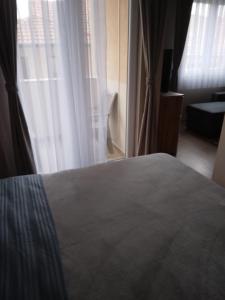 a bedroom with a bed and a large window at Gray Apartament 2 Pristina in Pristina