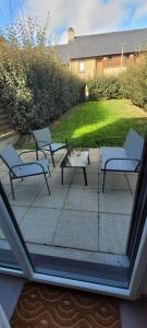 un groupe de chaises et une table sur une terrasse dans l'établissement Appartement Port-Mer près des plages, à Cancale