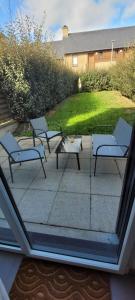a group of chairs and a table on a patio at Appartement Port-Mer près des plages in Cancale