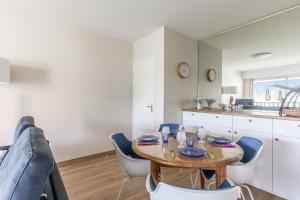 kuchnia i jadalnia ze stołem i krzesłami w obiekcie Superb apartment with balcony very close to the beach - Cabourg - Welkeys w mieście Cabourg