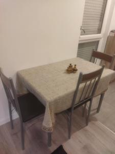 einen Esstisch mit 2 Stühlen und einem Tisch sowie einem Tisch und einem Stuhl in der Unterkunft Appartement neuf T2 dans résidence in Schiltigheim