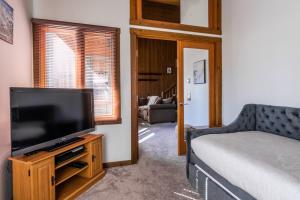 a living room with a flat screen tv and a bed at Mountainback 19 in Mammoth Lakes