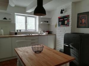 a kitchen with a wooden table and a black refrigerator at Gray apartment in Čukarica