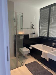 a bathroom with a shower and a tub and a sink at Die Vlei in Port Elizabeth