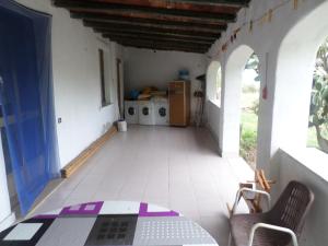 a room with a table and chairs and a kitchen at Pinnettu sardo tipica abitazione sarda in ecosistema, bagno esterno a 10metri Leggere attentamente Prima di prenotare in Oliena