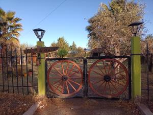 a gate with two woodenokedoked wheels and a fence at Quinta Los Olivos in Maipú