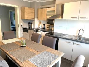 eine Küche mit einem Holztisch und eine Küche mit weißen Schränken in der Unterkunft Work & Study Apartment in Karlsruhe
