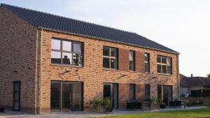 un edificio in mattoni rossi con finestre nere di De Hoog Velden 13 a Neerpelt