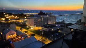 - un balcon offrant une vue sur la ville la nuit dans l'établissement Komfortable strandnahe Ferienwohnung A103 in 10 Etage mit Terrasse und Meerblick PARKING FREE, à Międzyzdroje