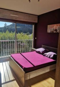een groot bed in een kamer met een groot raam bij Souvenirs de Provence T2 neuf avec loggia in Digne-les-Bains