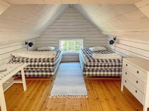 a attic room with two beds and a table at Holiday home ELLÖS IX in Ellös