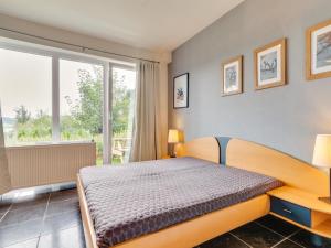 een slaapkamer met een bed en een groot raam bij Cosy holiday home with terrace in Winterberg in Winterberg