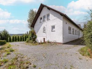 a white house with a gravel driveway at Cosy holiday home with terrace in Winterberg in Winterberg