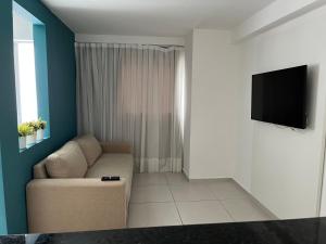 Il comprend un salon doté d'un canapé et d'une télévision à écran plat. dans l'établissement Maravilhoso apartamento em João Pessoa, à João Pessoa