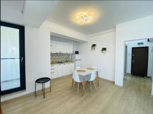 a kitchen with a table and chairs in a room at Alezzi Yacht Apartments with Sea View Near the Beach in Năvodari