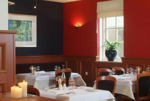 een restaurant met witte tafels en stoelen en een raam bij Hotel the Wigwam in Domburg