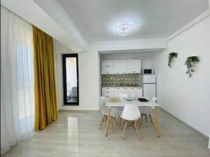 a kitchen and dining room with a table and chairs at Alezzi Yacht Apartments with Sea View Near the Beach in Năvodari